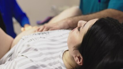 An obstetrician checks the opening of a young woman's labor in the maternity ward. A modern maternity ward with professional midwives.