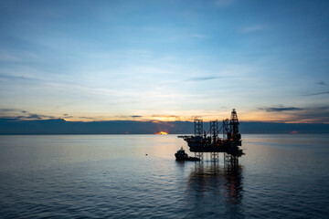 Aerial view of offshore jack up drilling rig during sunset - oil and gas industry.
