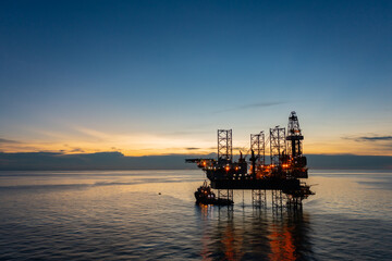 Aerial view of offshore jack up drilling rig during sunset - oil and gas industry.