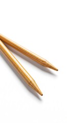 Close-up of two light brown wooden knitting needles against white background