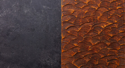 Natural black slate stone and texture of dragon scales on brown wood background pattern with high resolution. Copy space. Top view.