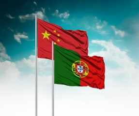  National flags of China and Portugal wave side by side in a clear blue sky symbolizing...