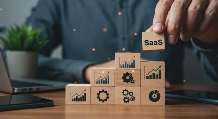 Obraz premium SaaS business structure and growth model. Person building tower of wooden blocks with SaaS and growth icons representing software, data, analytics, and business success