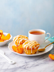 Muffins, peach fruit cupcakes with cup of tea. Grey background. Copy space.