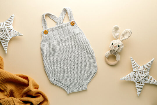 knitted baby romper and accessories on neutral fabric background flatlay newborn outfit