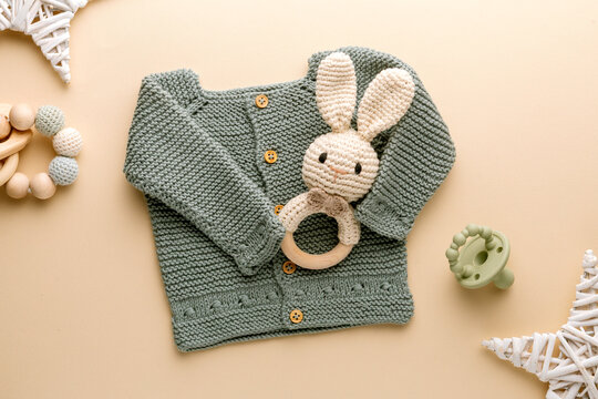 knitted baby romper and accessories on neutral fabric background flatlay newborn outfit
