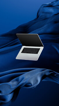 Light laptop on flowing fabric against a blue backdrop