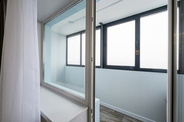 windows with black and silver frames. left window shows view of room. balcony overlooking street,...