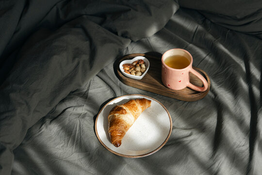 Homemade croissant on a bed with rustic wooden tray in warm lighting