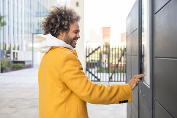Smiling businessman in yellow coat interacting with technology