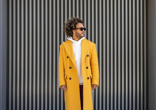 Stylish afro man in mustard coat with sunglasses