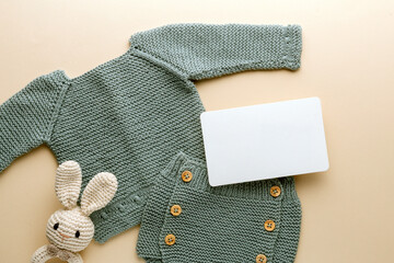 Newborn baby clothes mockup featuring hand-knitted, soft, and cozy babywear flatlay with a minimalist infant outfit