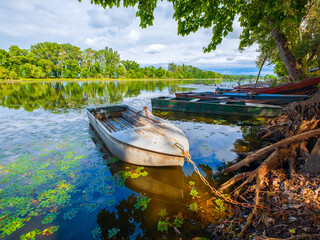 River Tisza in beautiful sunshine with pleasant colors, with wooden boats in the foreground during the day.