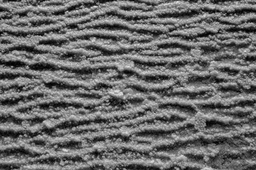 Waves of salt crystals on a salt lake. View of the surface of a salt lake, view from above. Wave structure of sedimentary salt deposits.