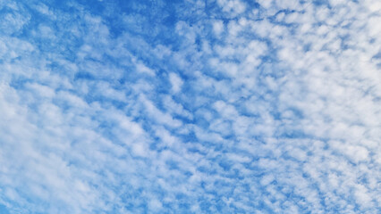 White cirrus clouds in the blue sky as a blue nature background