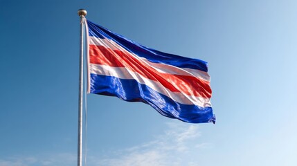 Fototapeta premium Costa Rican flag waving proudly on independence day against a clear blue sky