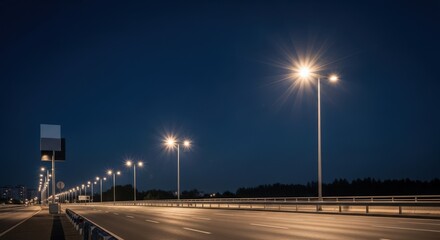 Empty highway road at night with streetlights illuminating the asphalt. Transportation infrastructure background. Long exposure night urban scene.