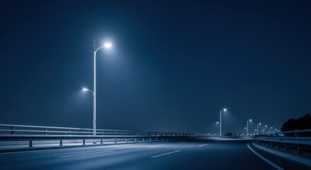 Dark empty highway at night with bright modern streetlights illuminating the road. Urban infrastructure for transportation.