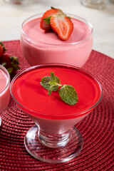 Tasty strawberry mousse in glass with gelatin on top