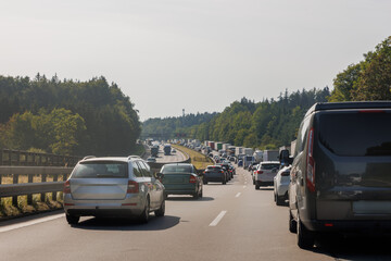 Back tail view of many cars stuck in row at highway road traffic jam cold overcast rainy winter day at Europe. Automobile accident vehicle rush hour collapse. Transportation vacation seasonal stuck