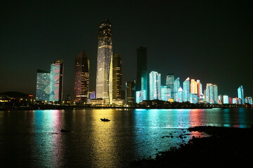 Obraz premium City Skyline Illuminated at Night with Reflections