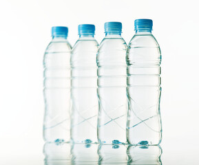 Four Plastic Water Bottles in a Row with Blue Caps