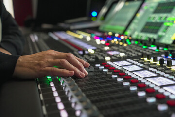Sound engineer's hand adjusting audio mixer console in Fernsehenstudio