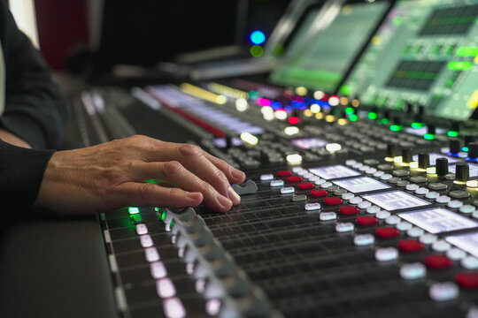 Sound engineer's hand adjusting audio mixer console in Fernsehenstudio