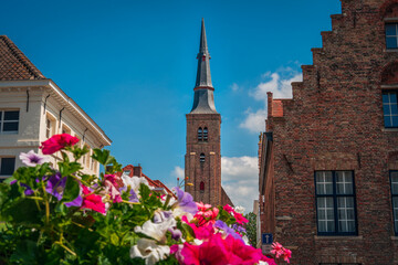 Fototapeta premium church of our lady of our lady in bruges belgium with flowers in summer