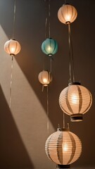 Obraz premium Hanging paper lanterns illuminate a dark room creating a warm light display.