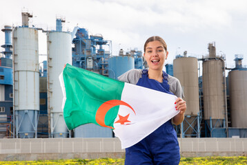near large industrial enterprise in Algerian outback,jubilant female employee in work overalls...