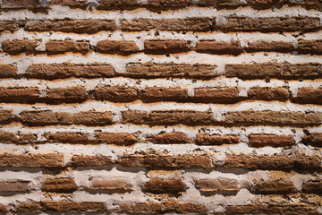 Texture of an old brick wall in a warm and very textured tone.