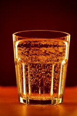 Glass of sparkling water on an elegant orange background