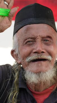 Elderly Indonesian man is feeling happy and smiling to the camera.