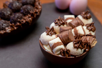 Chocolate easter eggs on top of black stone with wooden background