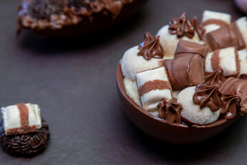 Chocolate easter eggs on top of black stone with wooden background
