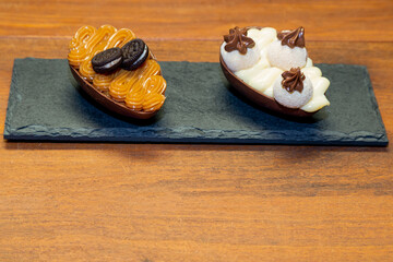 Chocolate easter eggs on top of black stone with wooden background