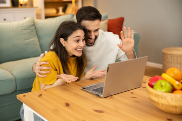 This scene captures a couple expressing their excitement and joy during a video chat, reinforcing...