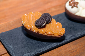 Chocolate easter eggs on top of black stone with wooden background