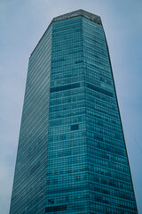 Obraz premium An apartment building with a modern architectural style with gray gradation colors. On a clear day the sky is cloudy blue.