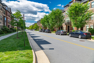 Modern apartment building with roadside parking. Urban development, landscaping.