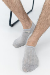 Men's legs in gray short socks on a white background