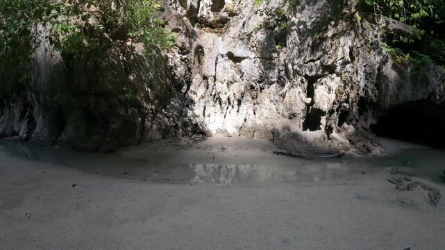 Panak İsland , a peaceful sandy beach surrounded by cliffs and greenery, with smooth sand and no visible footprints or human presence 
