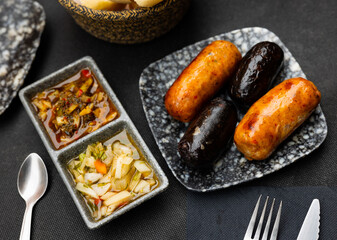 Appetizing sausages of Uruguayan cuisine Chorizo Criollo, grilled and served with two types of...