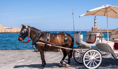 Chania Crete. Horse carriage and the lighthouse at the old venetian harbor