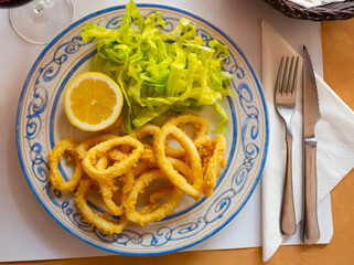 Fried calamari in a batter of tempera flour and fresh salad with lemon