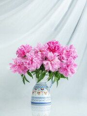 portrait view to bouquet of pink peonies with white background