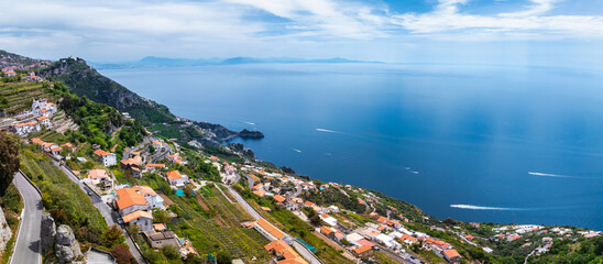 Aerial view of Amalfi, Italy, featuring terraced hills, whitewashed buildings, winding roads, and...