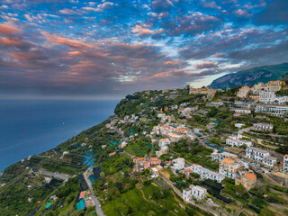 Aerial view of Ravello, Italy, with pastel buildings, terraced gardens, and the Mediterranean Sea...