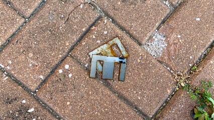 Rustic metallic emblem nestles in cobblestone, whispering tales of urban exploration, serendipitous...